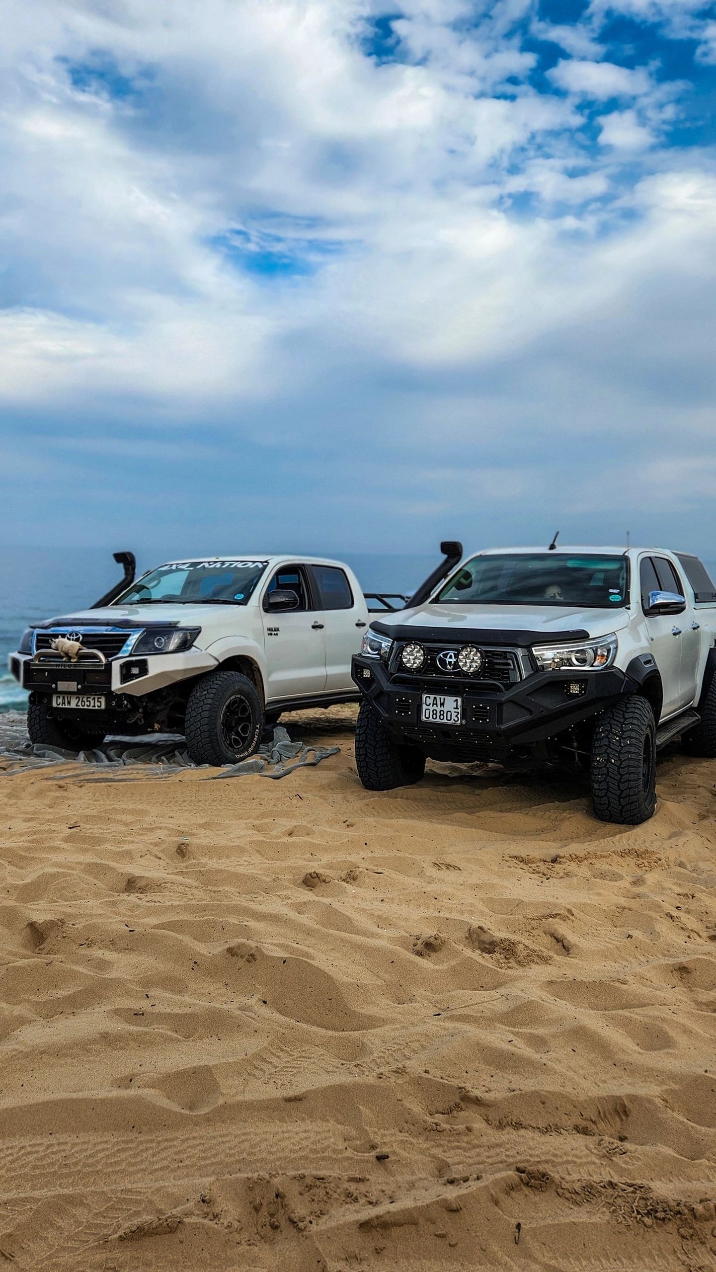 Modified pickup trucks parked on beach